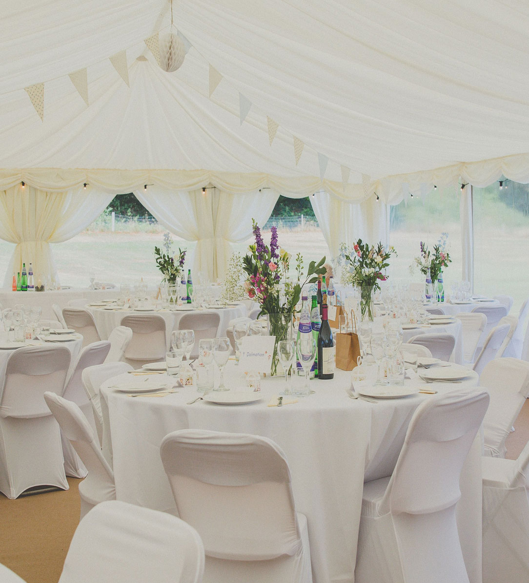 Inside marquee shot of decorated tables and furnishings
